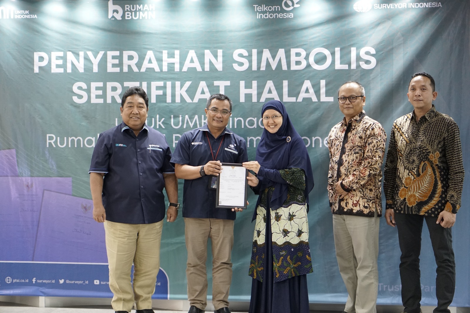 Kepala PMU Sertifikasi Surveyor Indonesia Afrinal (kedua dari kiri) menyerahkan simbolis sertifikat halal kepada perwakilan UMKM disaksikan Direktur Komersial Surveyor Indonesia Saifuddin Wijaya (paling kiri), Deputy EVP SOE Service Telkom, Fajar Wibawa (kedua dari kanan) dan SM Rumah BUMN Telkom Adrian Sani Harahap di Jakarta beberapa waktu yang lalu. ( Foto : Istimewa )