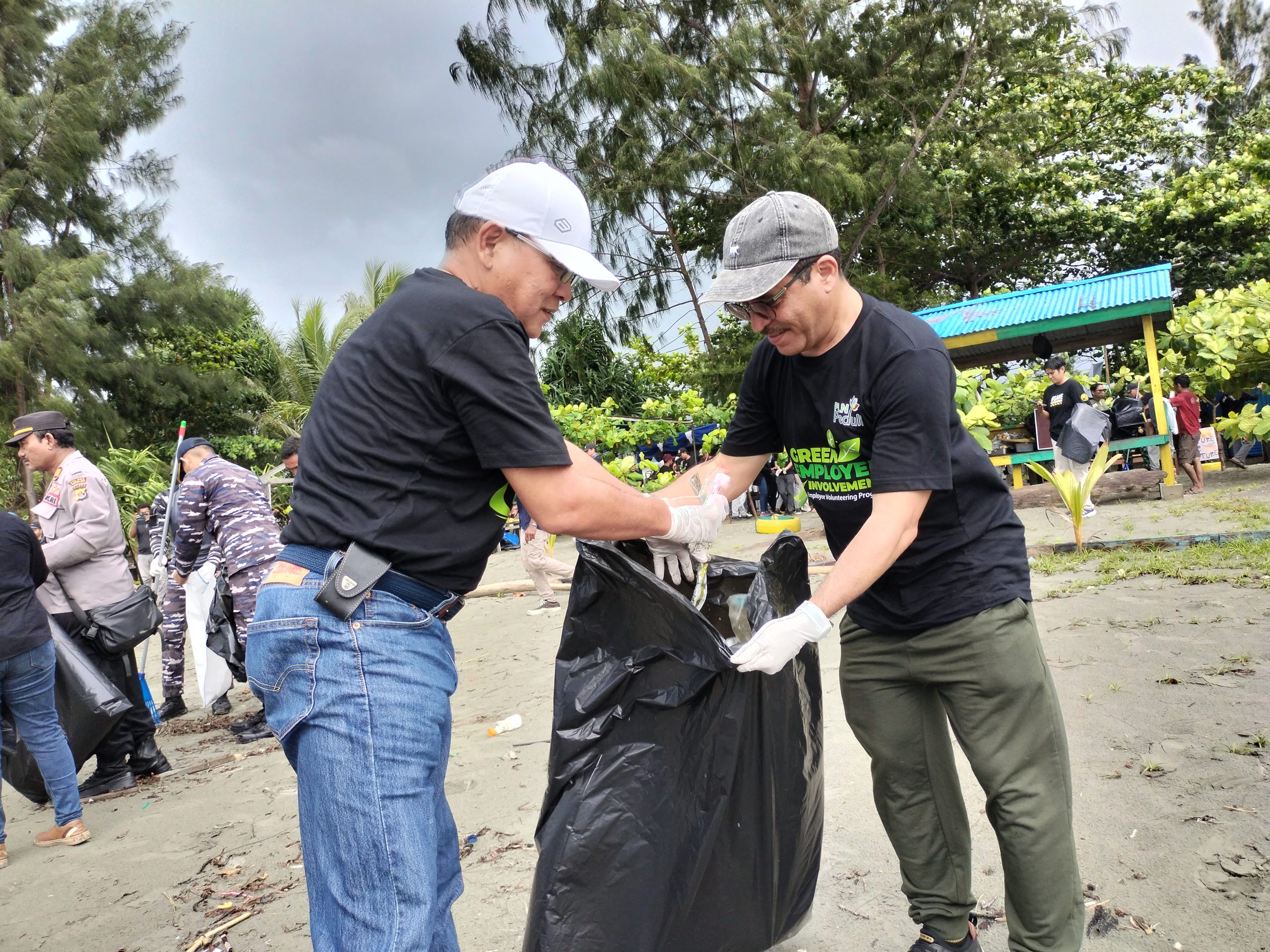 General Manager PLN UIP MPA, Wisnu Kuntjoro Adi (kiri ) bersama para karyawan PLN UIP MPA dan komunitas rumah bakau dalam aksi gerebek sampah di tepi pantai Holtekamp muara Tami. Jayapura, Senin ( 3/6). ( Foto : Muhammad Kasim )