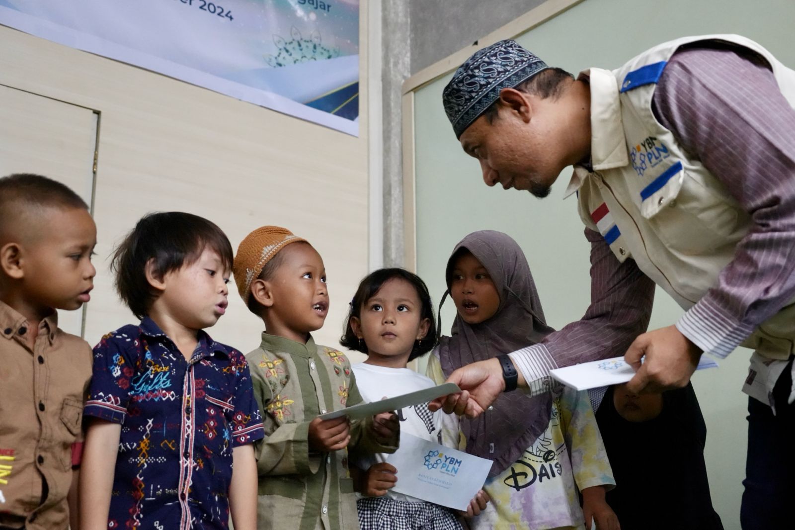 Senior Manager Keuangan, Anggaran dan Umum PLN UIP MPA, Fazli Arrazaq membagikan bantuan kepada anak anak di Jayapura, Kamis ( 26/9). ( Foto : Istimewa )