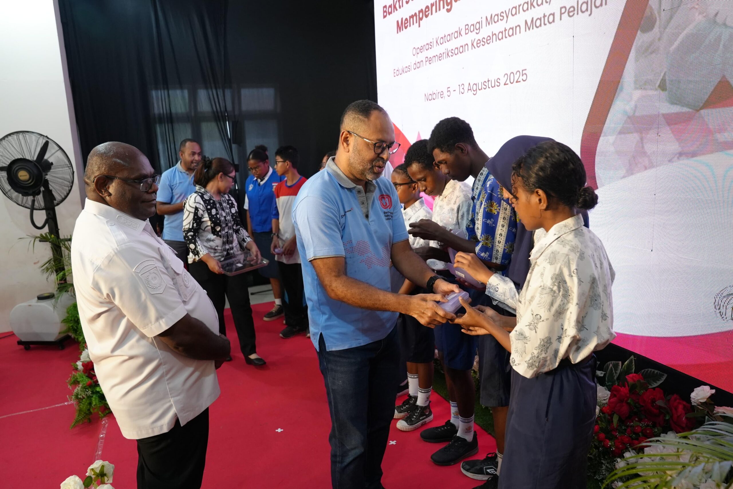 Executive Vice President (EVP) Sustainable Develoment PTFI Claus Wamafma disaksikan Gubernur Papua Tengah Meki Nawiwa, menyerahkan simbolis bantuan kaca mata gratis dari PTFI untuk 487 pelajar di Nabire. ( Foto : Istimewa )